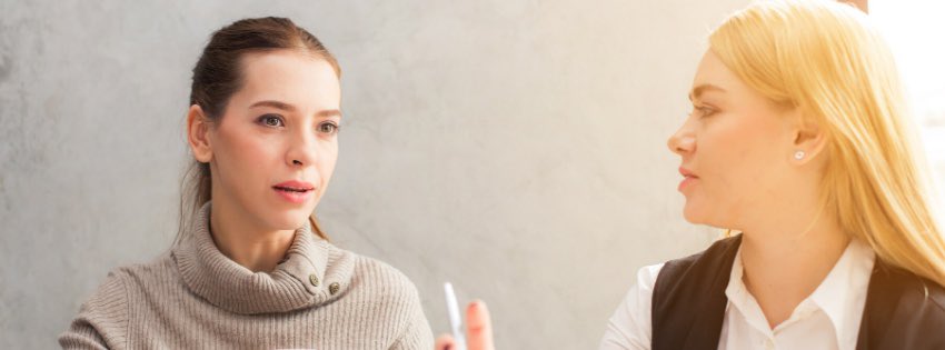 Dve ženy sa zapájajú do rozhovoru v interiéri. Brunetka v sivom roláku pozorne počúva, ako blondínka v bielej košeli a čiernej veste živo gestikuluje. Zdá sa, že zahalení v jasnom svetle sprava sa sústredili na to, ako „zlepšiť svoju komunikáciu.